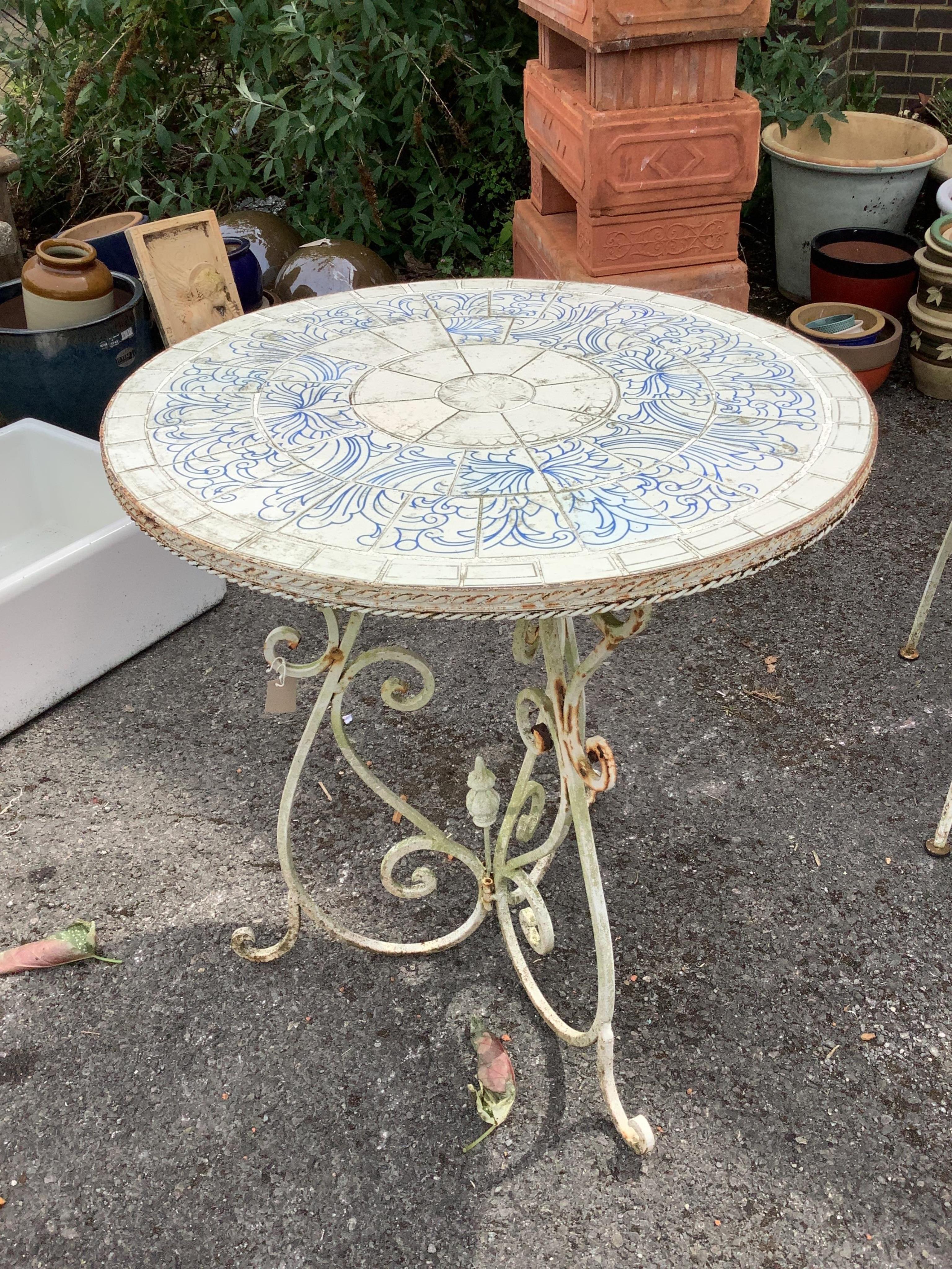 A wrought iron circular tiled top garden table, diameter 70cm, height 76cm